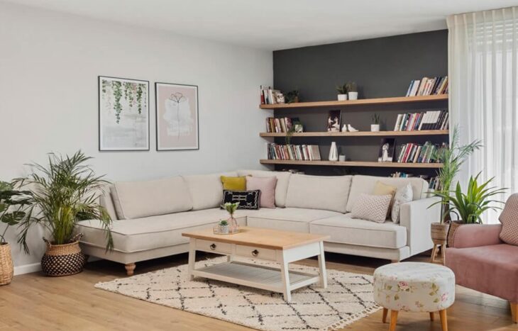 סלון מעוצב בשילוב כורסאות, ריהוט עץ, צמחים, וילונות ואמנות קיר. עיצוב מודרני ונעים.